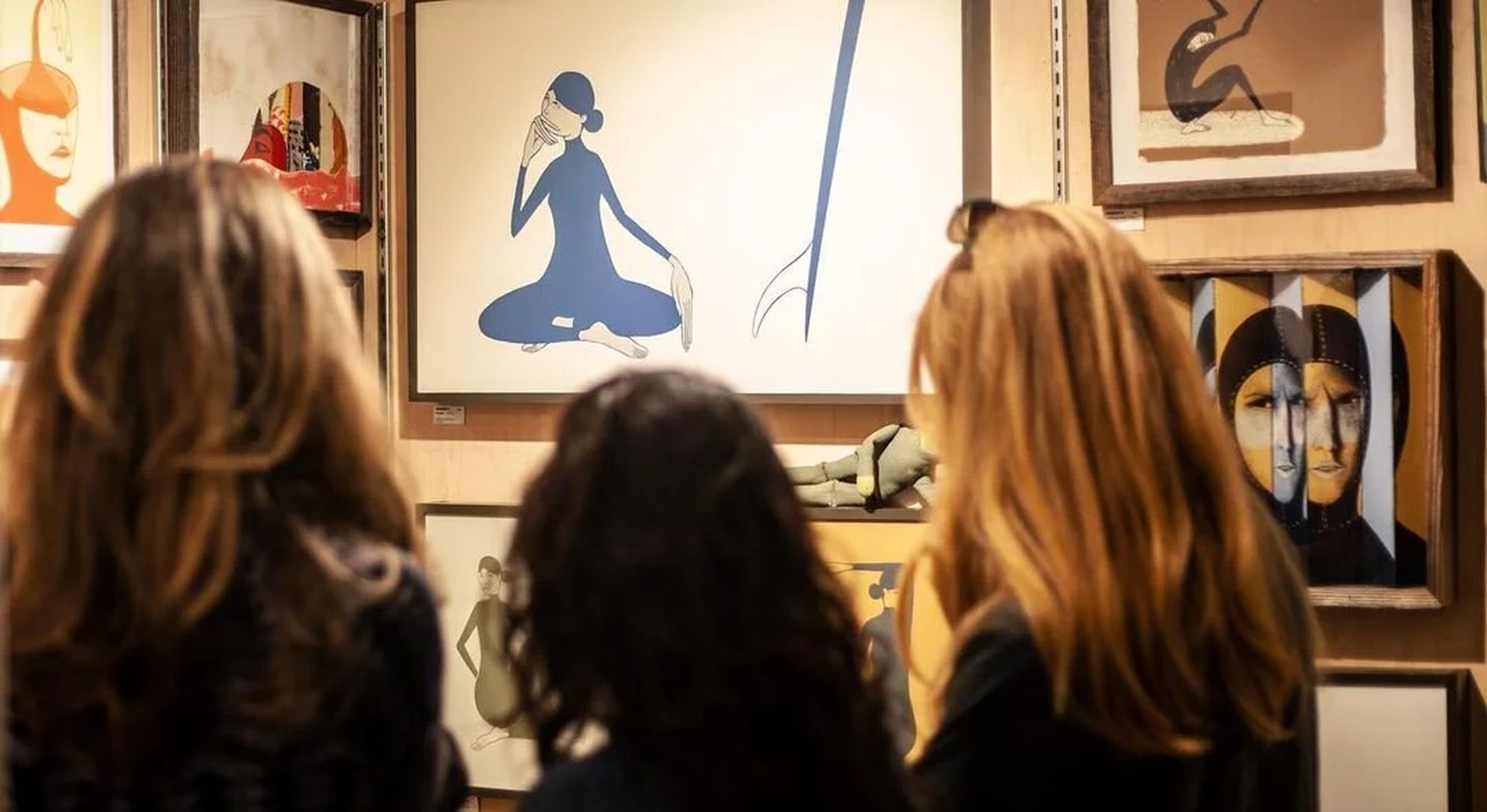 Gallery visitors looking at Knoffy surf art